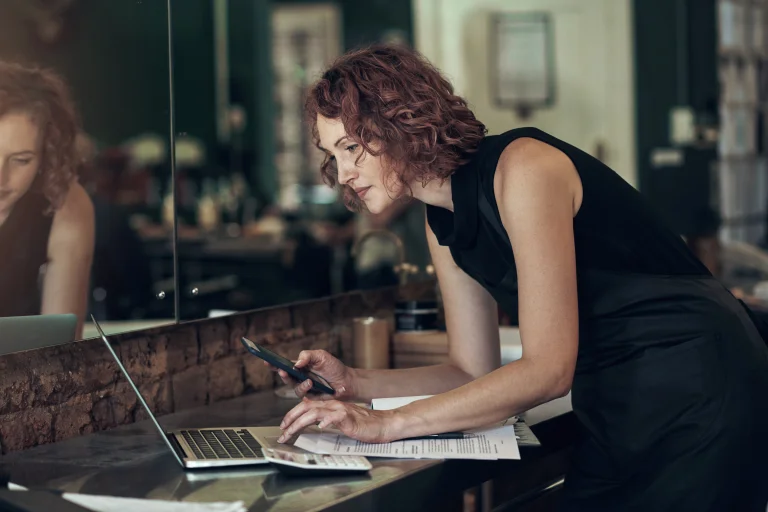 Faire Vermittlung, symbolisiert durch eine Frau mit Laptop Unterlagen und Handy