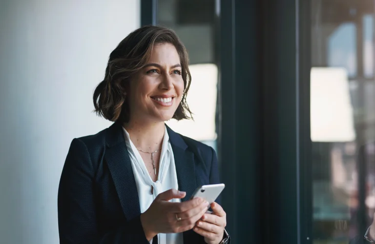 Eine Frau mit Handy in der Hand, freut sich über risikofreie Prozessfinanzierung
