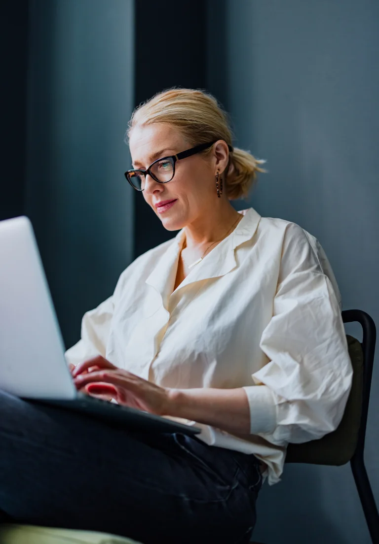 Eine Frau mit einem Laptop prüft ein Inkassounternehmen auf Seriosität