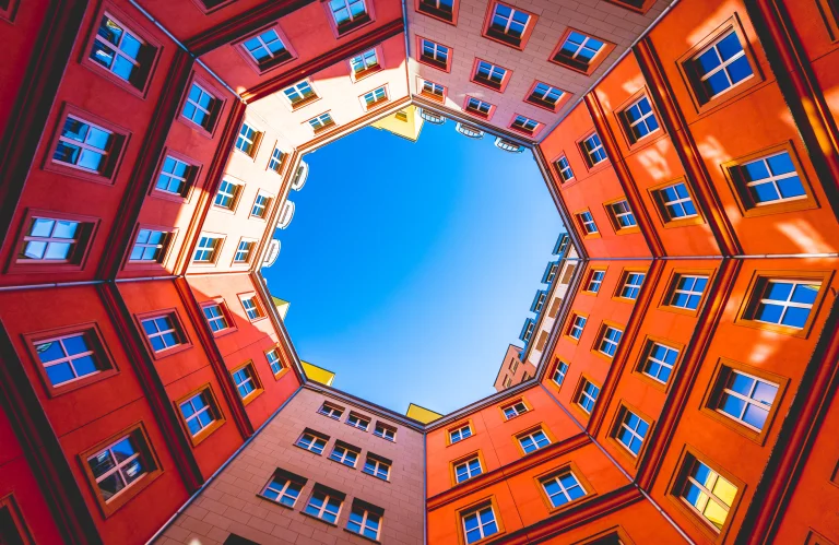 Der Innenhof eines Gebäudes im roten Licht von unten in den Himmel fotografiert